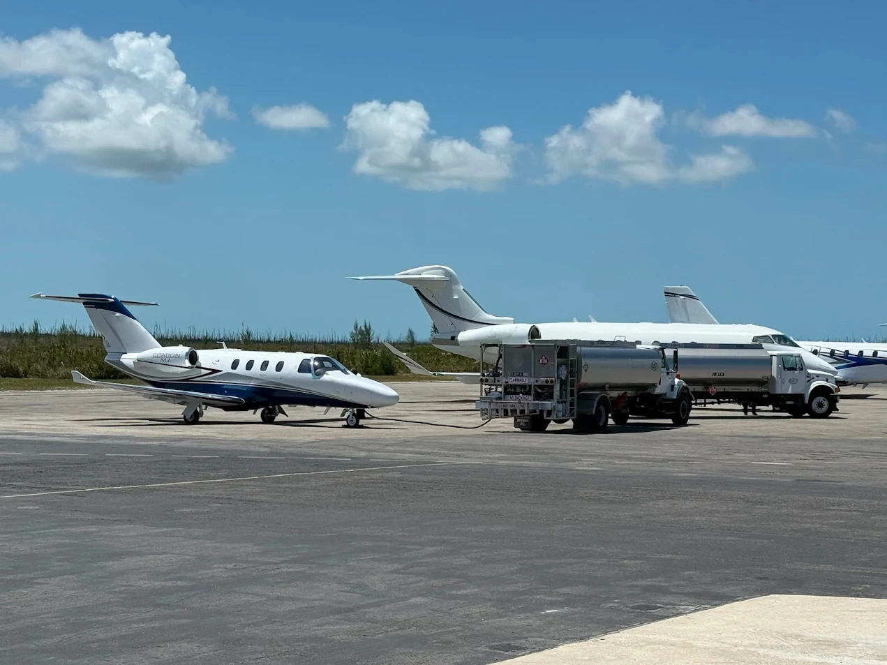 Private jets parked on airport runway fueling